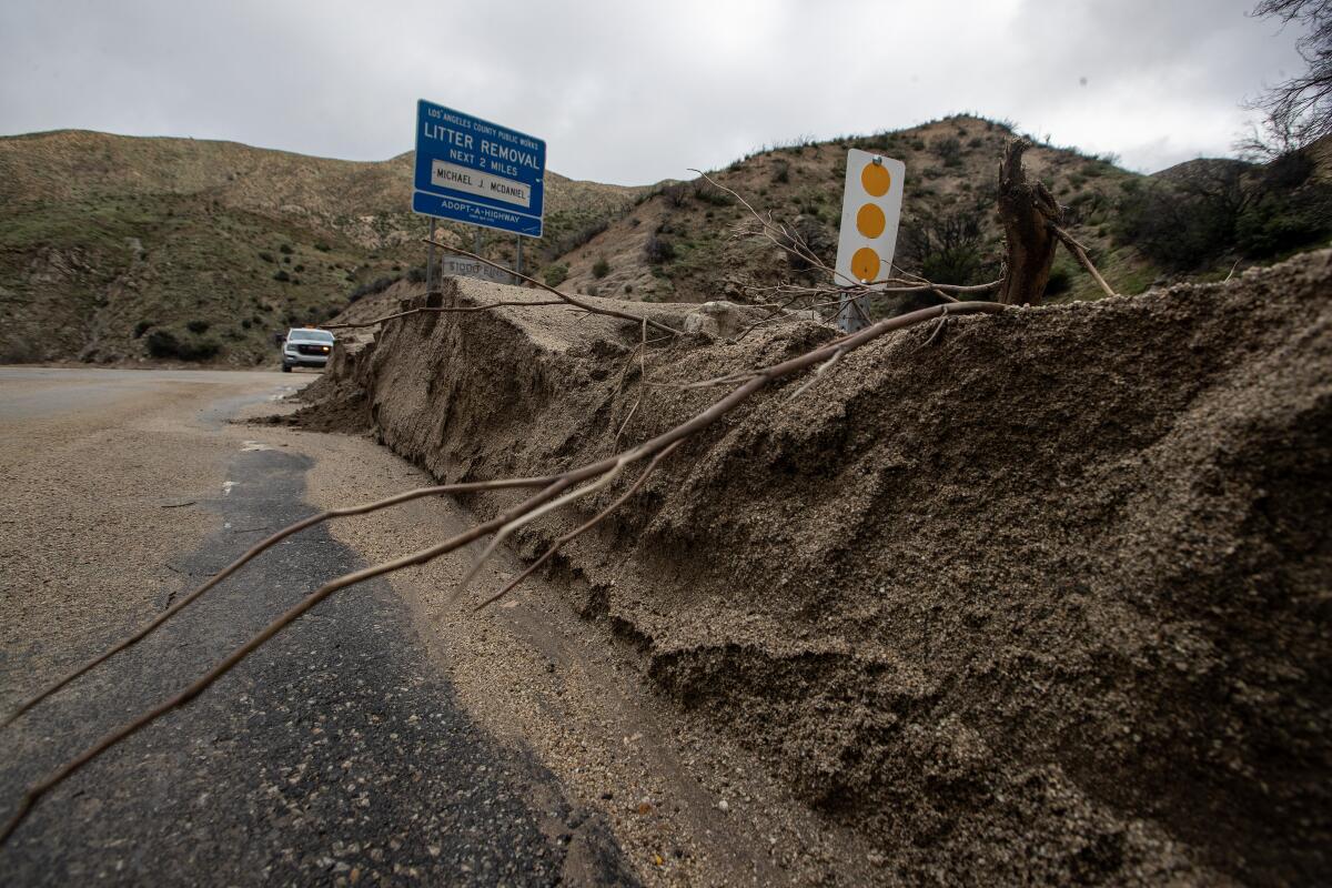 A two-foot berm of sand and dirt line Lake Hughes Road where September storms washed out 