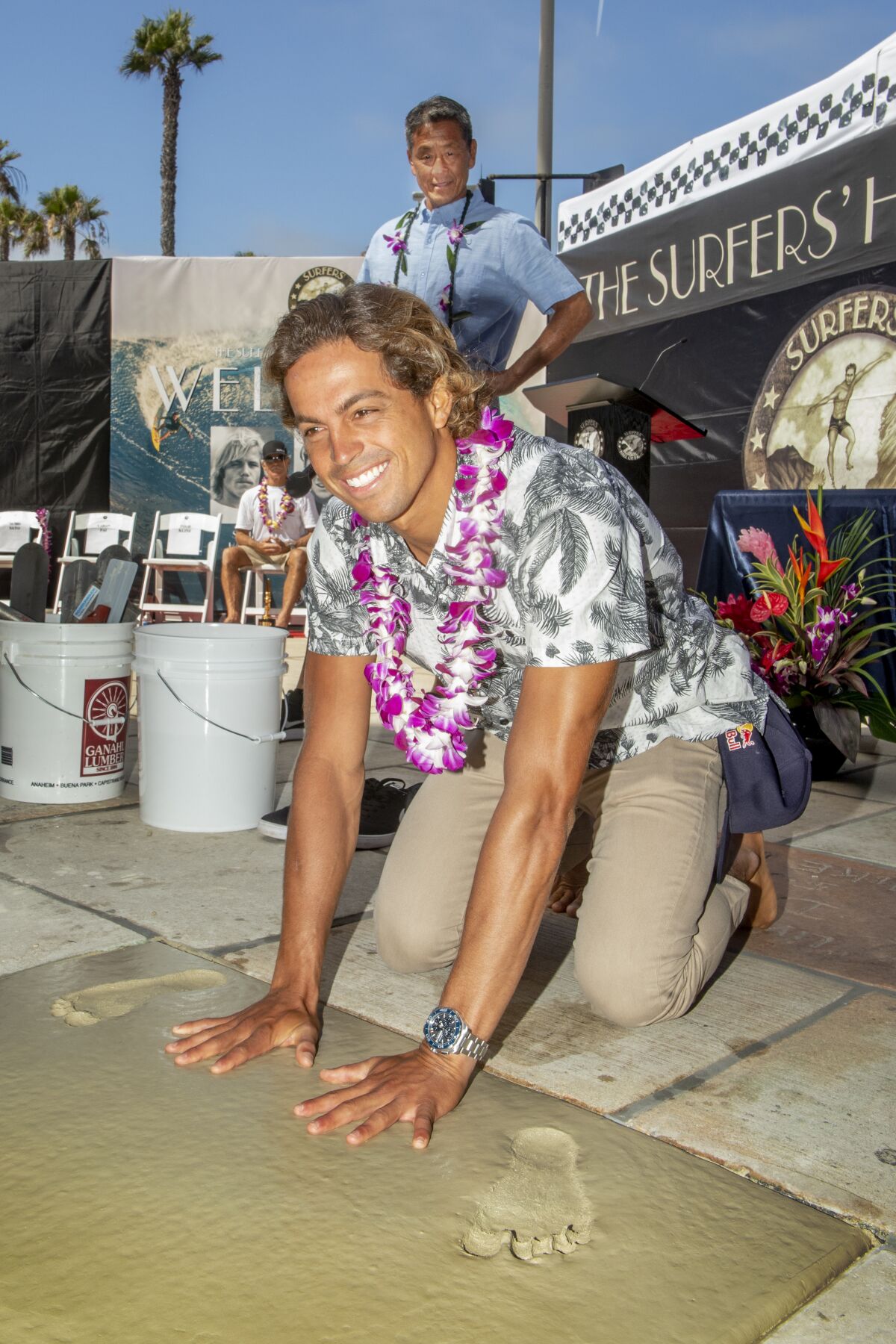 Kai Lenny plants his handprints in wet cement during his induction into the Surfers' Hall of Fame.