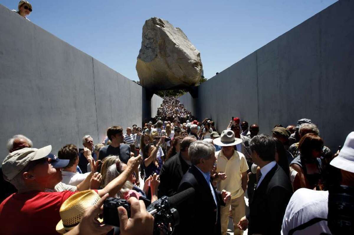 Michael Heizer, shown in cowboy hat and yellow shirt at LACMA, and his piece "Levitated Mass" are the subject of a new documentary.