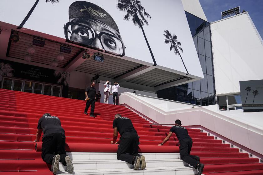 Personal instala la alfombra roja en el Palais des Festival para la inauguración de la 74ta edición del Festival Internacional de Cine de Cannes, el martes 6 de julio de 2021 en Cannes, Francia. (AP Foto/Brynn Anderson)