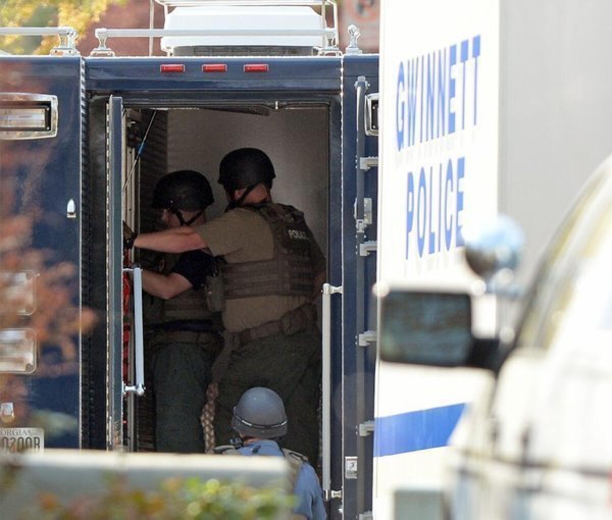 The Gwinnett County police work at the home in Suwanee, Ga., where five firefighters had been taken hostage.