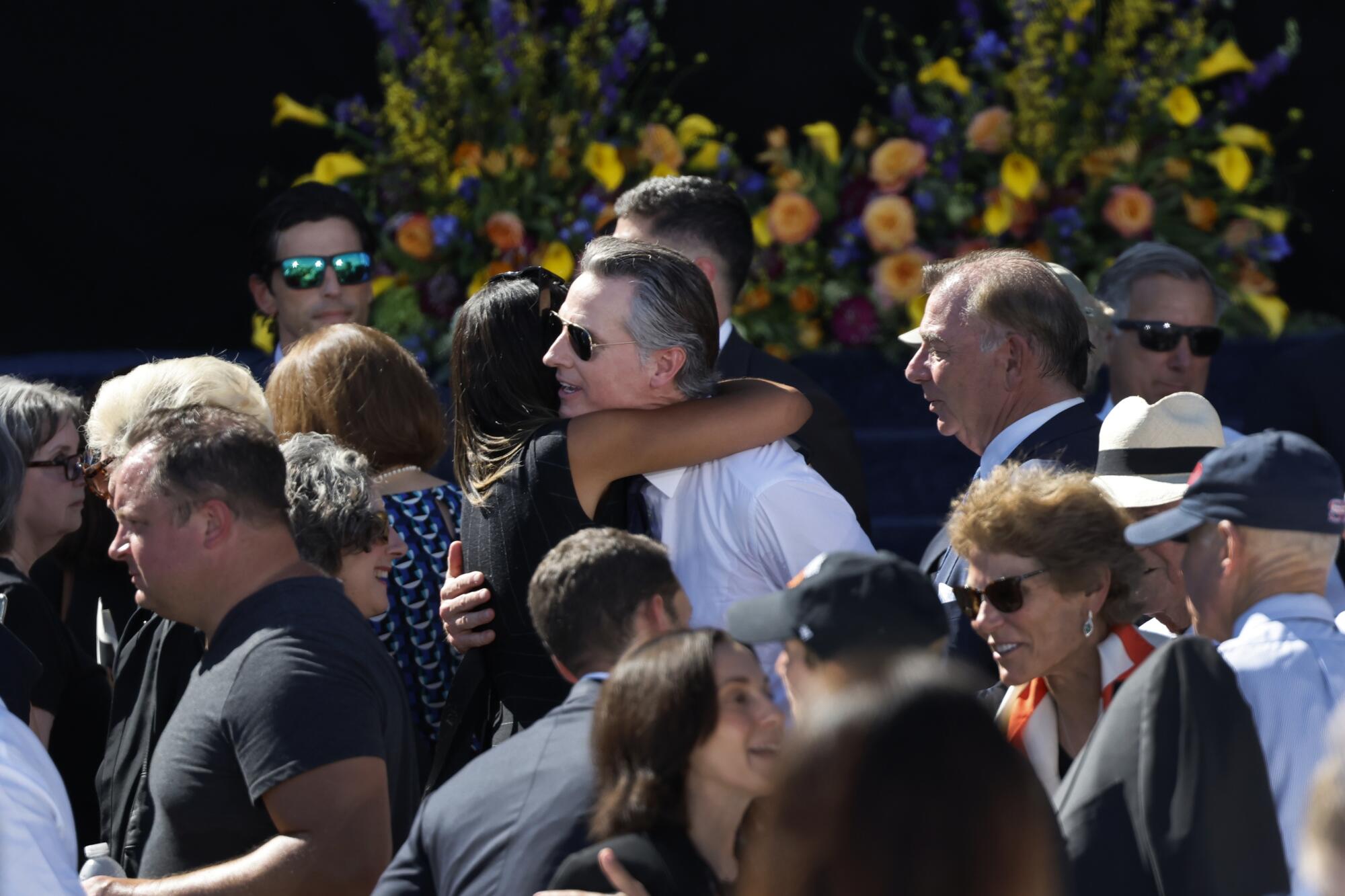 Gov. Gavin Newsom hugs an invited guest after the memorial service in honor of the late U.S. Sen. Dianne Feinstein.