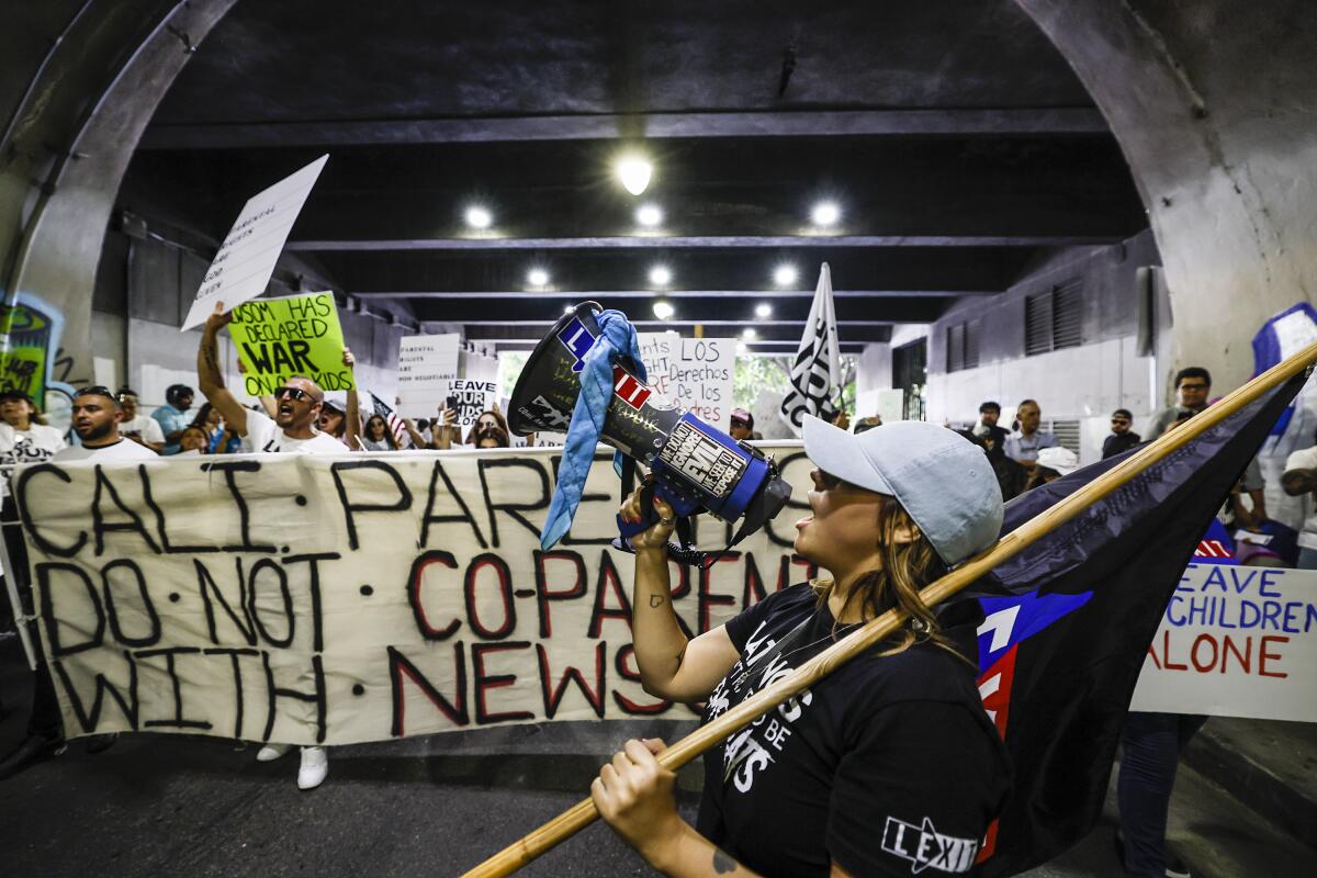 Protesters carrying a large banner march through a tunnel.