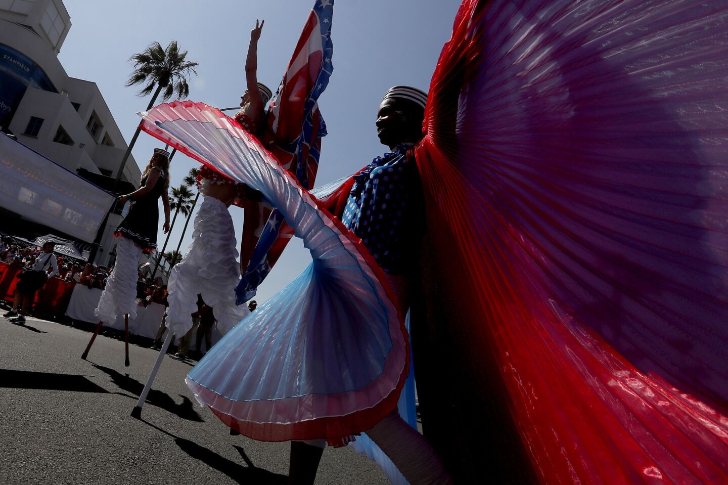 Dancers and stilt walkers turn down Main Street off Pacific Coast Highway during the annual Independence Day Parade in Huntington Beach.