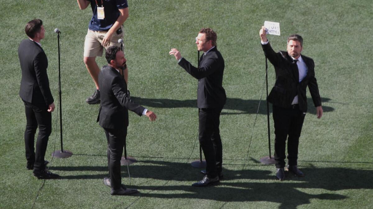 Pemigio Pereira holds up sign after the Tenors' performance at the All-Star Game in July.