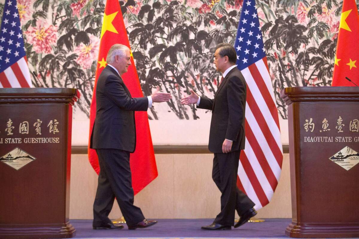 Secretary of State Rex Tillerson and China's Foreign Minister Wang Yi reach to shake hands at the end of a joint press conference at the Diaoyutai State Guesthouse in Beijing on March 18, 2017.