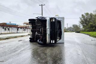 In this photo provided by Chris Leavitt, an overturned truck lies on a street Thursday, May 25, 2023, in Yigo, Guam, after Typhoon Mawar passed over the island. (Chris Leavitt via AP)