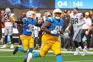 Chargers defensive tackle Poona Ford (95) celebrates after his interception against the Raiders.