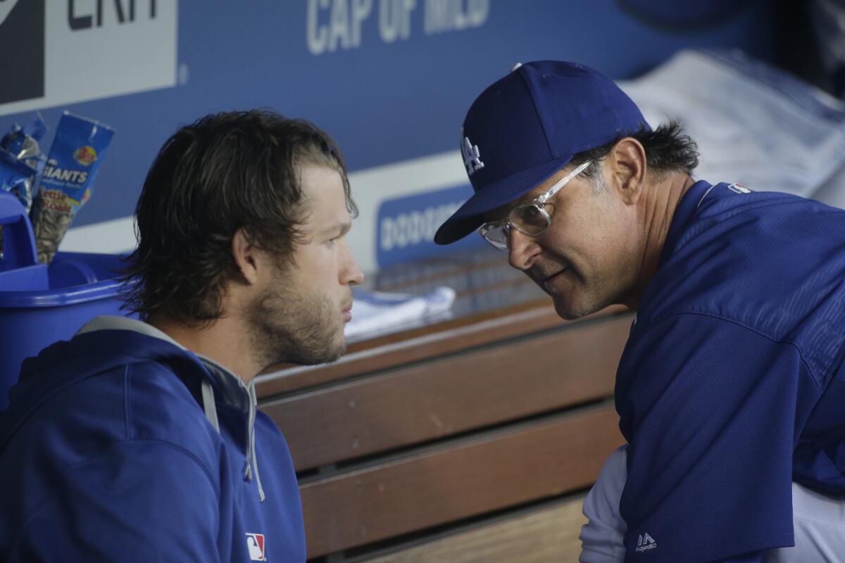 Dodgers Manager Don Mattingly, right, talks to pitcher Clayton Kershaw before Friday's game. Kershaw was scratched from his start, but is expected to pitch Saturday.