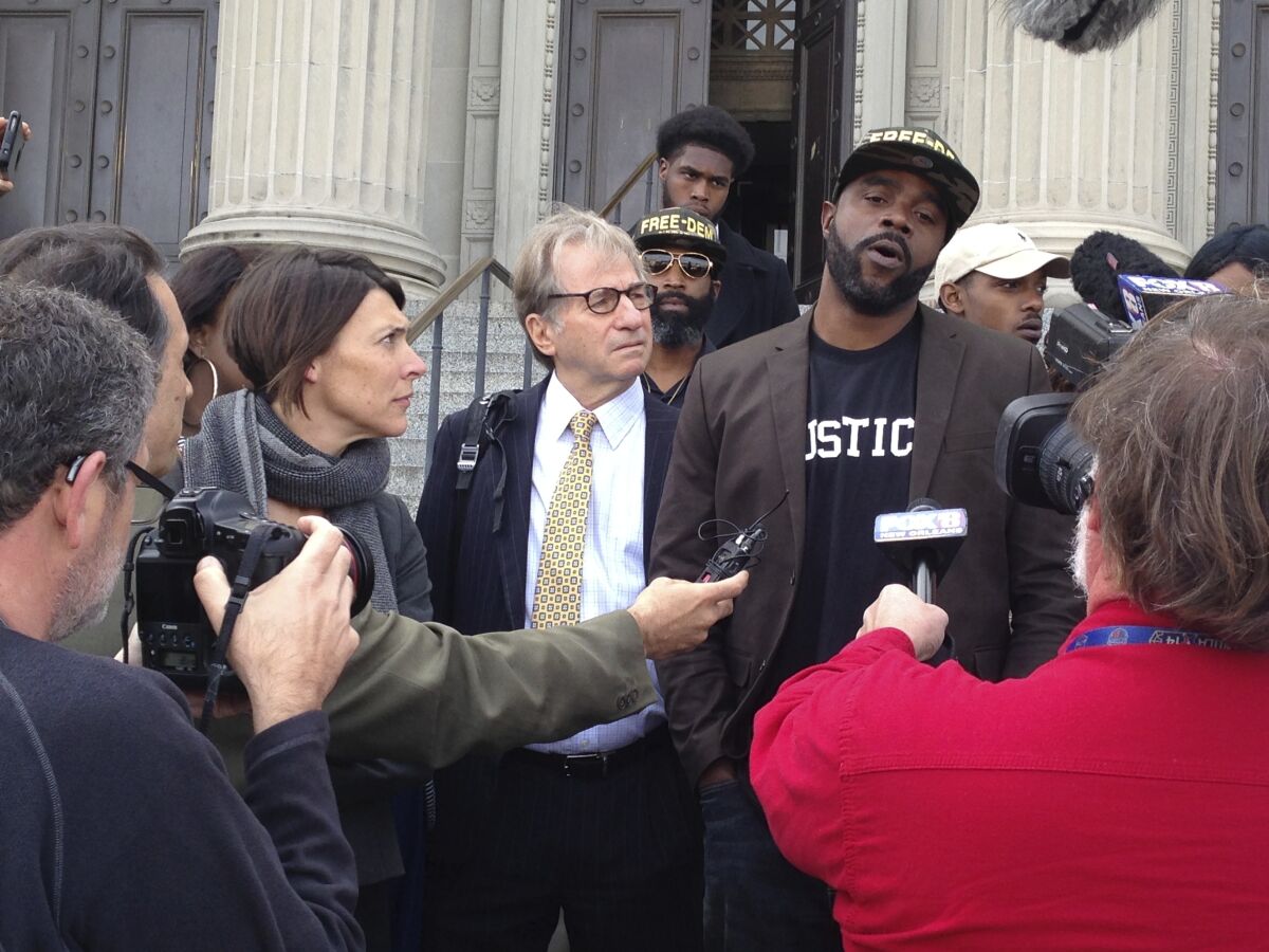 FILE - In this Jan. 26, 2017, file photo, Robert Jones, right, speaks with reporters, with defense attorneys Emily Maw, left, and Barry Scheck, at the New Orleans courthouse. Local prosecutors have reached a $2 million settlement with the New Orleans man who spent 23 years in prison before being cleared on charges that included rape and manslaughter. District Attorney Jason Williams said he reached the settlement Tuesday, Aug. 17, 2021 with Robert Jones, who was formally cleared of the charges on his 44th birthday in 2017. (AP Photo/Kevin McGill, File)