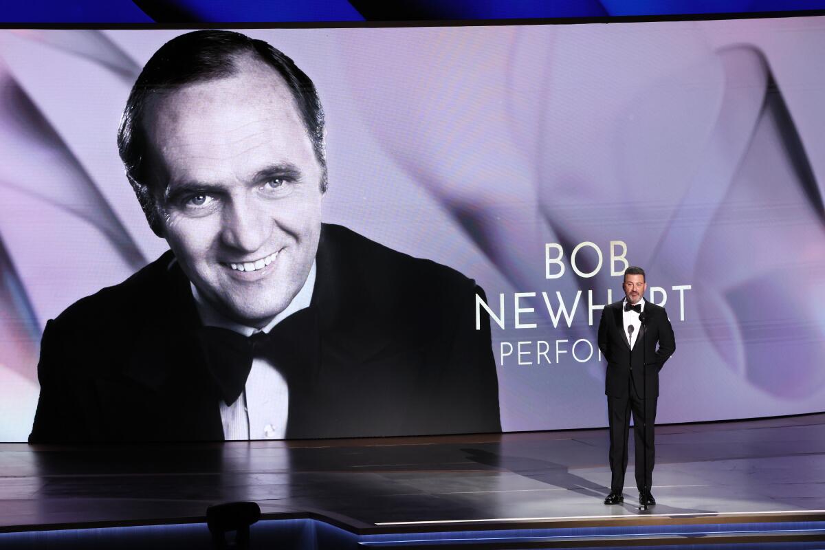 A black-and-white image of Bob Newhart on a screen with Jimmy Kimmel standing in front of it.