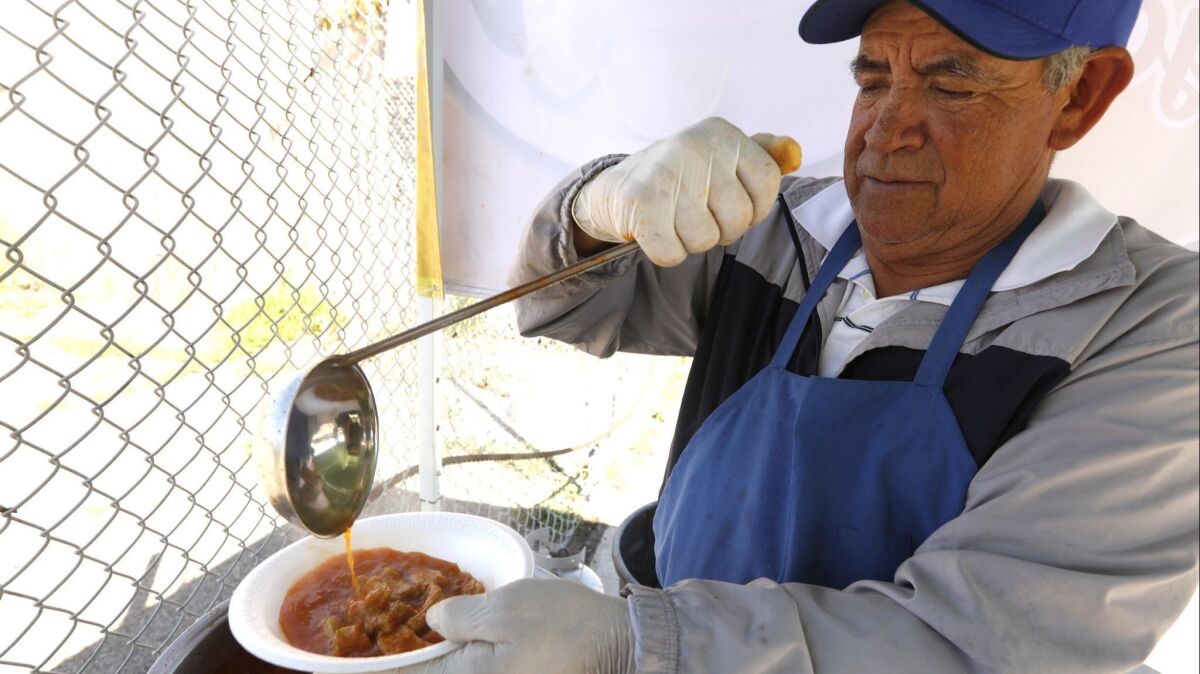 Joel Mendez prepares a bowl of menudo at his Mr. Menudo pop-up stand in Compton. Mendez is a 25-year veteran of the beloved Juanito's in East L.A.