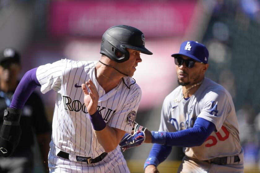Colorado Rockies' Nolan Jones is tagged out by Dodgers second baseman Mookie Betts on Sept. 26, 2023, in Denver.
