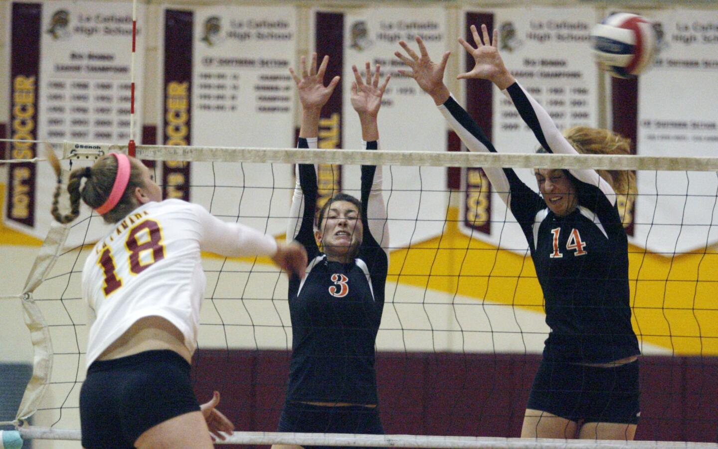 La Canada's Micaela Anderson, from left, spikes the ball as South Pasadena's Jessica Arroyo and Claire Kieffer-Wright attempt to block the spike during a game at La Canada High School on Tuesday, October 16, 2012.