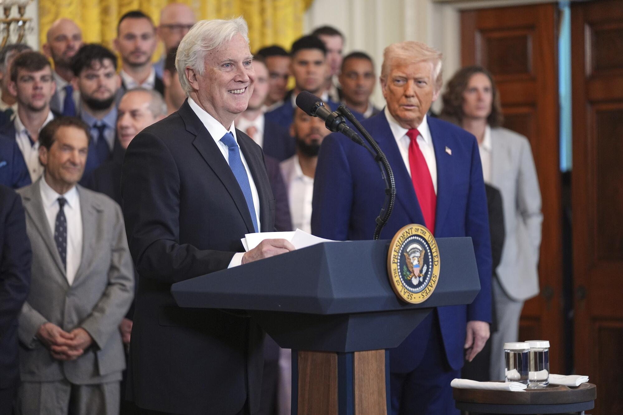 President Donald Trump listens as Los Angeles Dodgers owner and chairman Mark Walter.