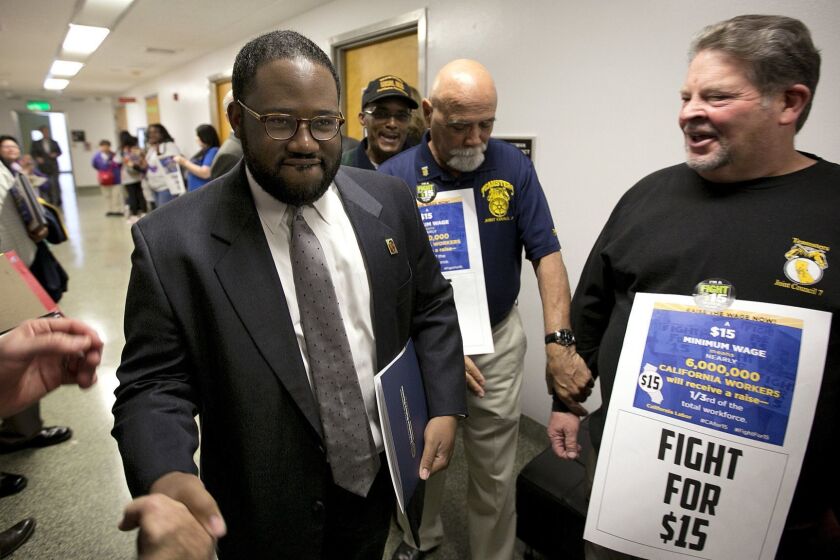 Assemblyman Sebastian Ridley-Thomas, D-Los Angeles, center, is greeted by supporters of a measure to raise the state's minimum wage as he walks to the Assembly Thursday, March 31, 2016, in Sacramento, Calif. California state lawmakers are expected to vote on a proposal to gradually raise California's minimum wage to a nation leading $15 an hour by 2022. (AP Photo/Rich Pedroncelli)