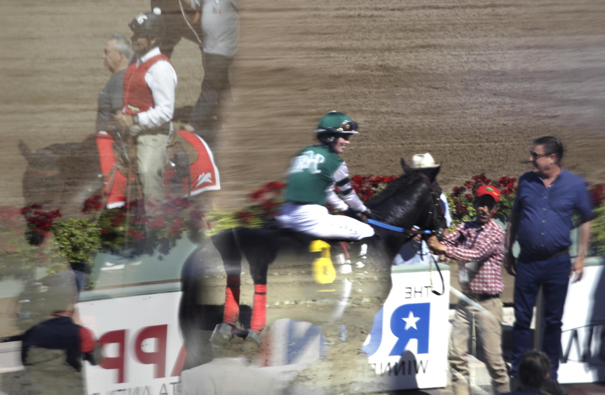  A reflection of a green-helmeted jockey on a horse 