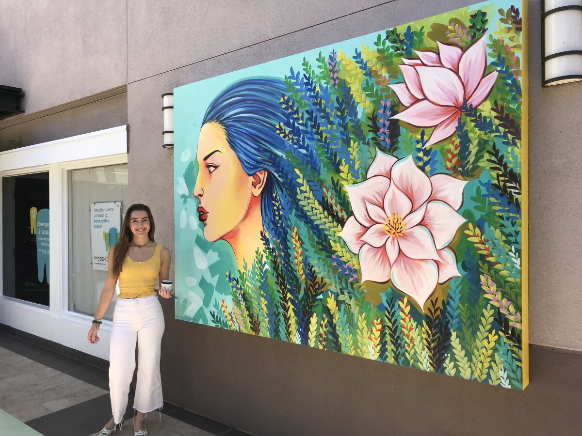 Marina Alberti with her mural at Flower Hill Promenade.