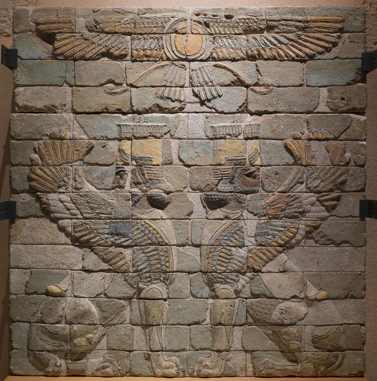Two carved sphinxes face each other on a brick panel.
