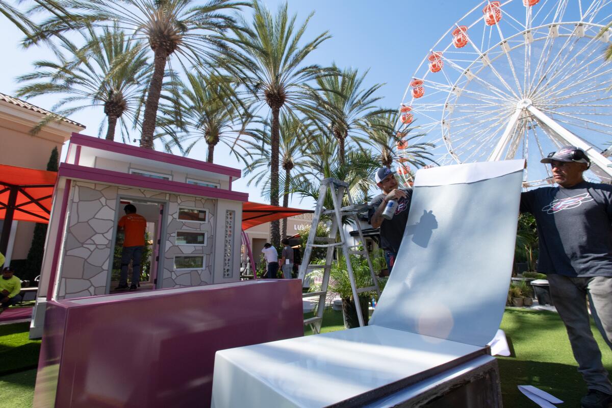 Crews put together furniture for entries in Project Playhouse at the Irvine Spectrum.