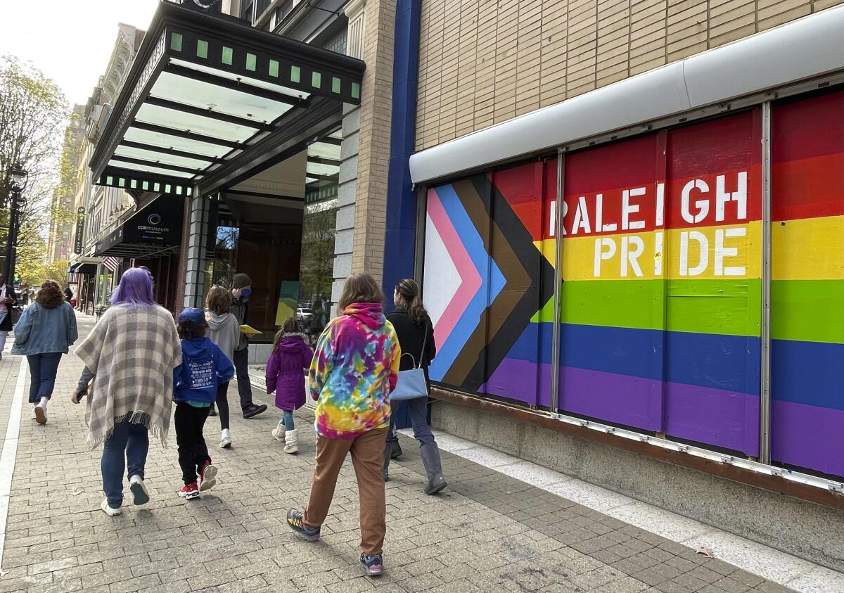 People pass a mural reading "Raleigh Pride."