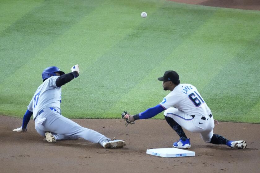 Los Angeles Dodgers' Shohei Ohtani, left, of Japan, steals second base as Miami Marlins second baseman Otto Lopez (61) waits for the throw during the first inning of a baseball game, Wednesday, Sept. 18, 2024, in Miami. (AP Photo/Wilfredo Lee)