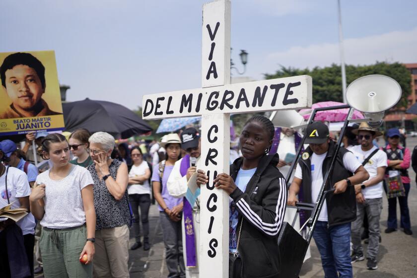 Migrants and Catholics hold an Easter-related event to remember migrants who have died, disappeared, are imprisoned, or have been maimed, with a Way of the Cross procession in Guatemala City, Friday, March 15, 2024. The cross reads in Spanish "Way of the Migrant Cross." (AP Photo/Moises Castillo)