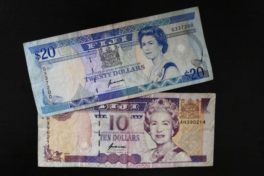 Fiji $10 and $20 bills bills are pictured in Sydney, Saturday, Sept. 10, 2022. As the United Kingdom's reigning monarch, Queen Elizabeth II was depicted on British bank notes and coins for decades. It's less well known that her portrait was featured on currencies in dozens of other places around the world, in a reminder of the British empire's colonial reach. (AP Photo/Mark Baker)