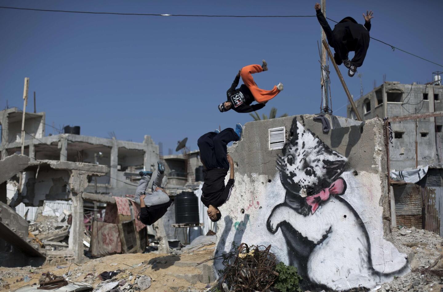 Youths practice their Parkour skills near a mural said to have been painted by British street artist Banksy in conflict-ravaged Beit Hanoun.