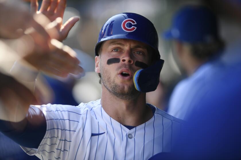 Chicago Cubs' Nico Hoerner celebrates in the dugout with teammates after scoring on an Ian Happ double during the first inning of a baseball game against the Colorado Rockies, Saturday, Sept. 23, 2023, in Chicago. (AP Photo/Paul Beaty)