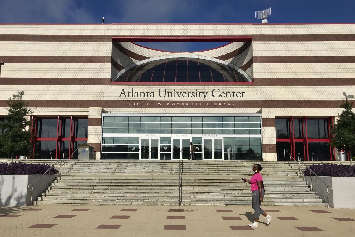 A woman walks past an entrance to Clark Atlanta University 