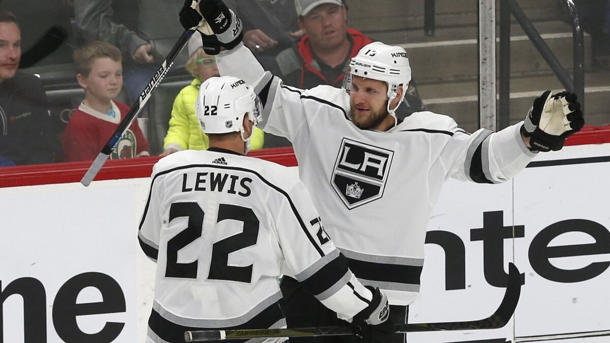 Kings' Kyle Clifford, right, and Trevor Lewis celebrate Clifford's goal off Minnesota Wild's goalie Devan Dubnyk in the third period on Thursday.
