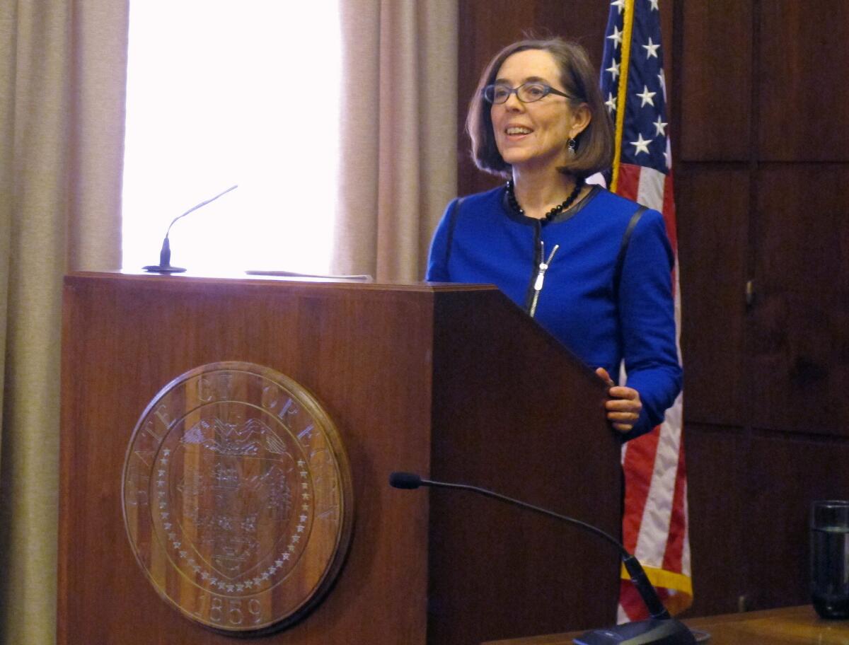 Oregon Gov. Kate Brown, shown speaking to reporters last month in Salem, on Friday signed legislation abolishing the state's troubled health insurance exchange.
