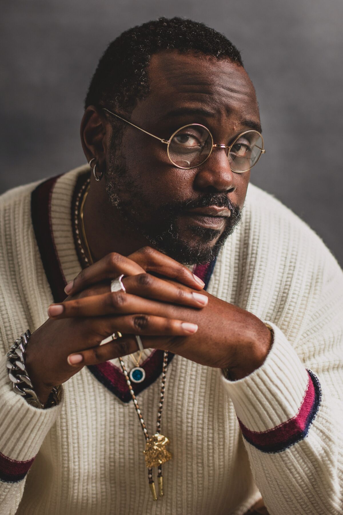 Brian Tyree Henry folds his hands in front of him for a portrait.