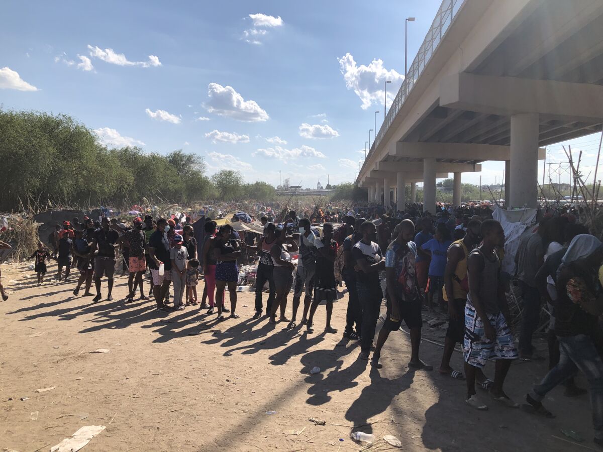 Migrants waiting in line for food at the camp near the border bridge in Del Rio, Texas.