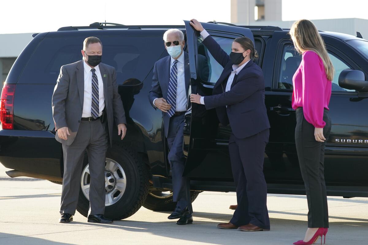 Joe Biden steps out of his van at Raleigh-Durham International Airport; granddaughter Finnegan Biden looks on.