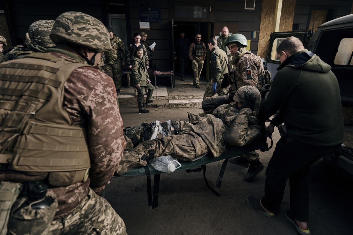 Ukrainian soldiers carrying a wounded comrade