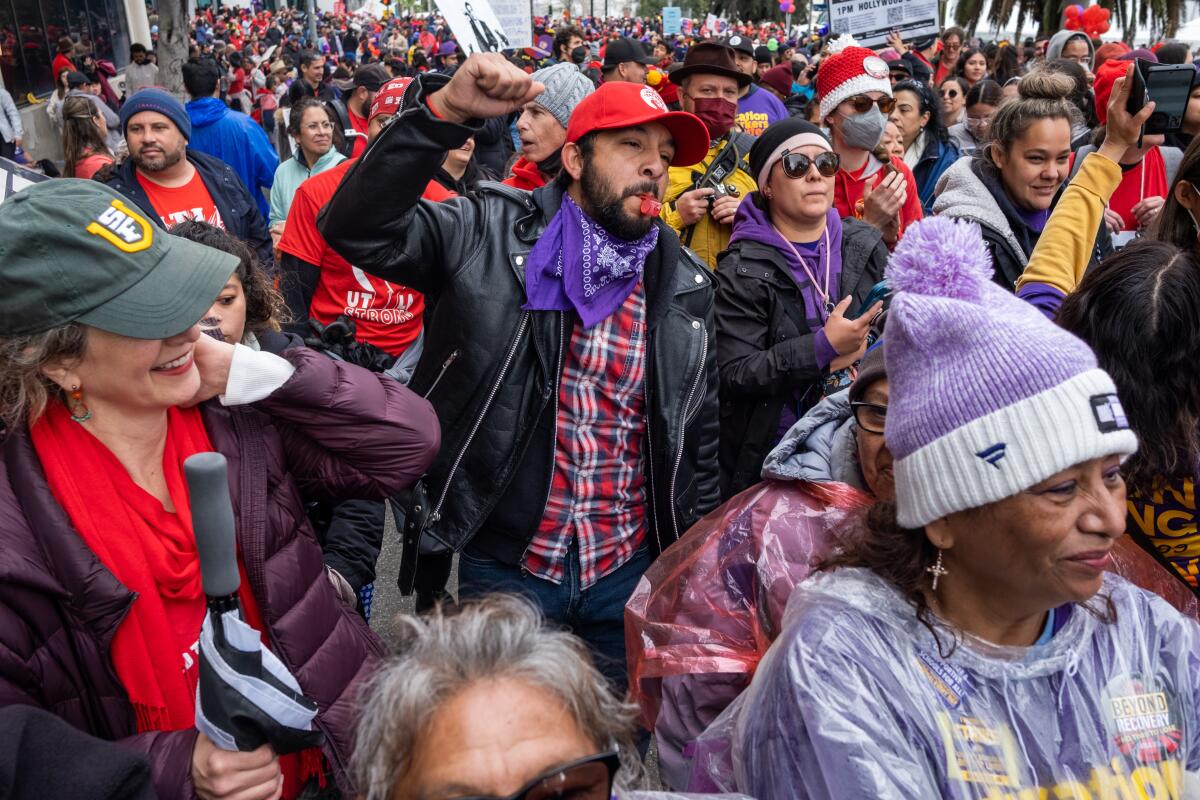 A man in a crowd of people raises a fist.