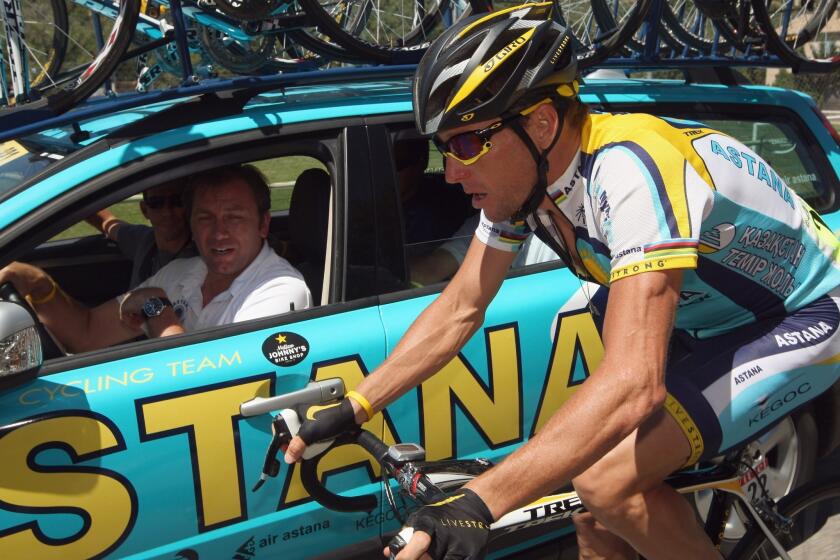 Lance Armstrong talks to team manager Johan Bruyneel driving alongside during the 2009 Tour de France.