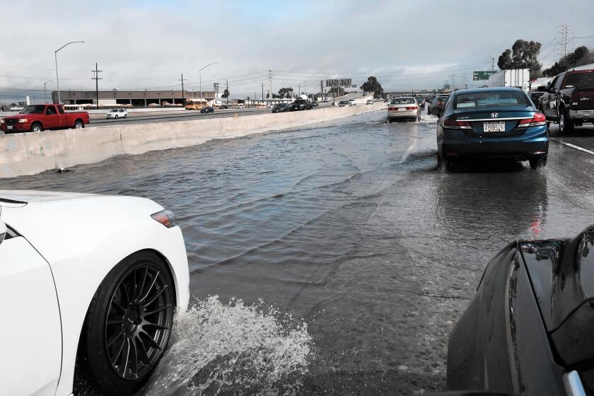 Cars slow down while going through deep water on the 110 Freeway on Tuesday morning.