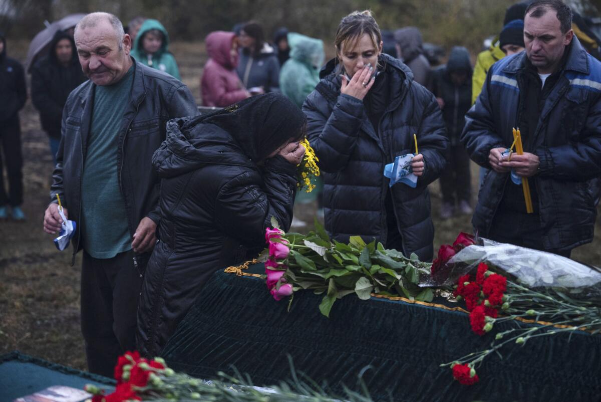 Relatives and friends mourn near coffins.