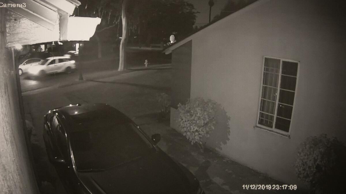 An image from home surveillance video released by the Los Angeles Police Department shows a white Toyota speeding down 3rd Avenue in South Los Angeles with its hatch open after a possible kidnapping on Nov. 12. Witnesses reported hearing a woman's screams, which were also captured by a home security system.