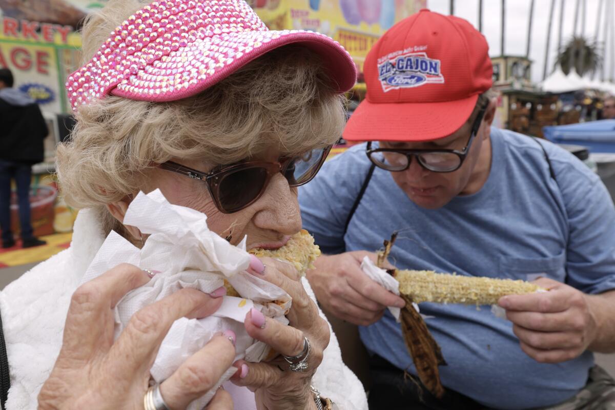 El Cajon resident Joanne Snow, 87, and her son, Russell Snow, eat corn at the San Diego County Fair.
