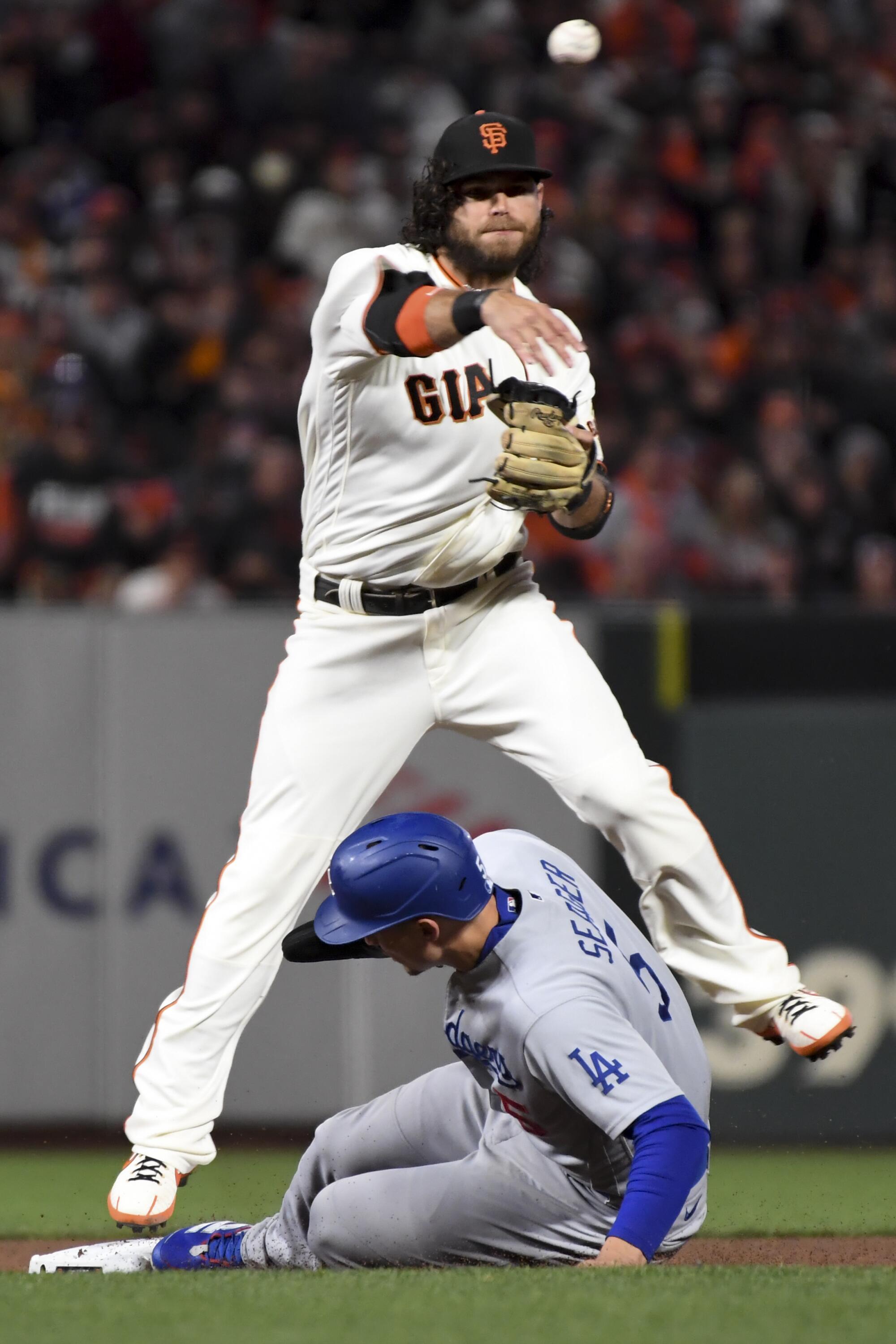 Giants' Brandon Crawford throws to first after forcing out Dodgers' Corey Seager