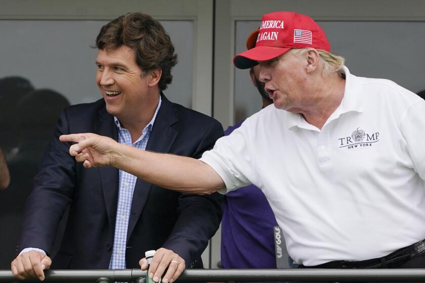 Tucker Carlson, left, and former President Donald Trump, talk while watching golfers on the 16th tee during the final round of the LIV Golf Invitational at Trump National in Bedminster, N.J., July 31, 2022. A defamation lawsuit against Fox News is revealing blunt behind-the-scenes opinions by its top figures about Donald Trump, including a Tucker Carlson text message where he said “I hate him passionately.” Carlson's private conversation was revealed in court papers at virtually the same time as the former president was hailing the Fox News host on social media for a “great job” for using U.S. Capitol security video to produce a false narrative of the Jan. 6, 2021, insurrection. (AP Photo/Seth Wenig, File)