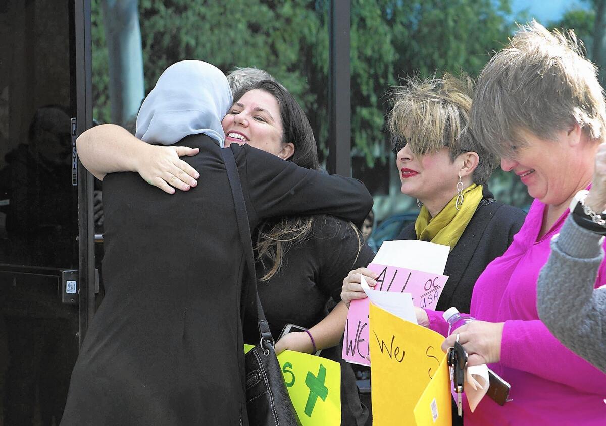 Rev. Sarah Halverson-Cano, with fellow Interfaith Council members, hugs a member of the Islamic Educational Center of Orange County in a gesture of religious solidarity and support in light of recent events in Paris and San Bernardino.