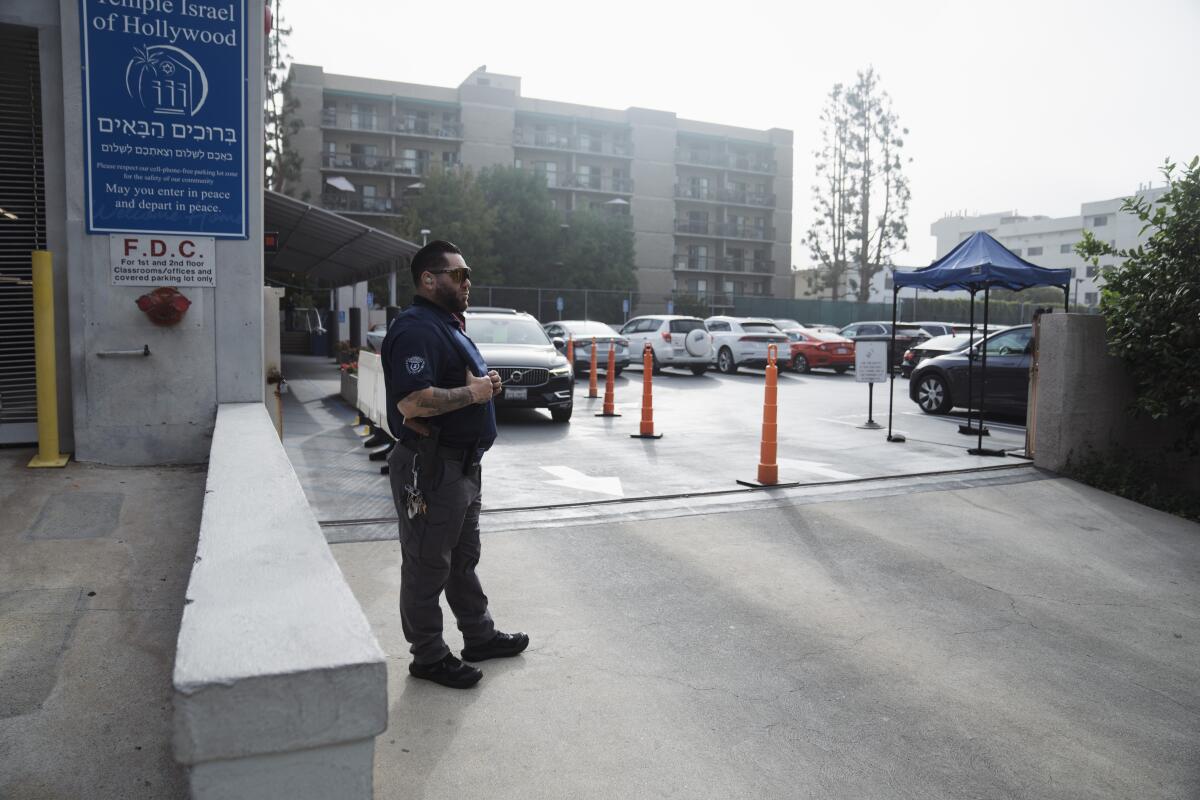 A security guard stands watch in front of a synagogue on October 9, 2023 in Los Angeles, California.