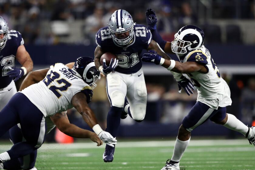 ARLINGTON, TEXAS - DECEMBER 15: Ezekiel Elliott #21 of the Dallas Cowboys runs the ball against Dante Fowler #56 of the Los Angeles Rams in the second half at AT&T Stadium on December 15, 2019 in Arlington, Texas. (Photo by Ronald Martinez/Getty Images)