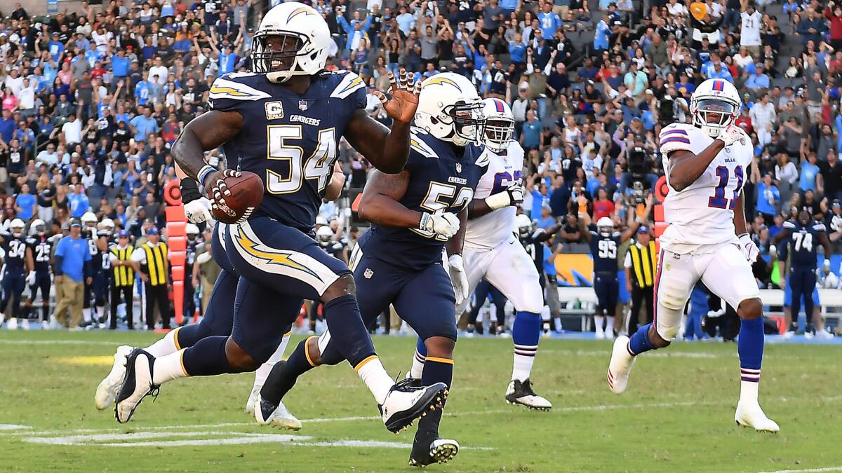Chargers defensive end Melvin Ingram picks up a fumble by Bills quarterback Tyrod Taylor.