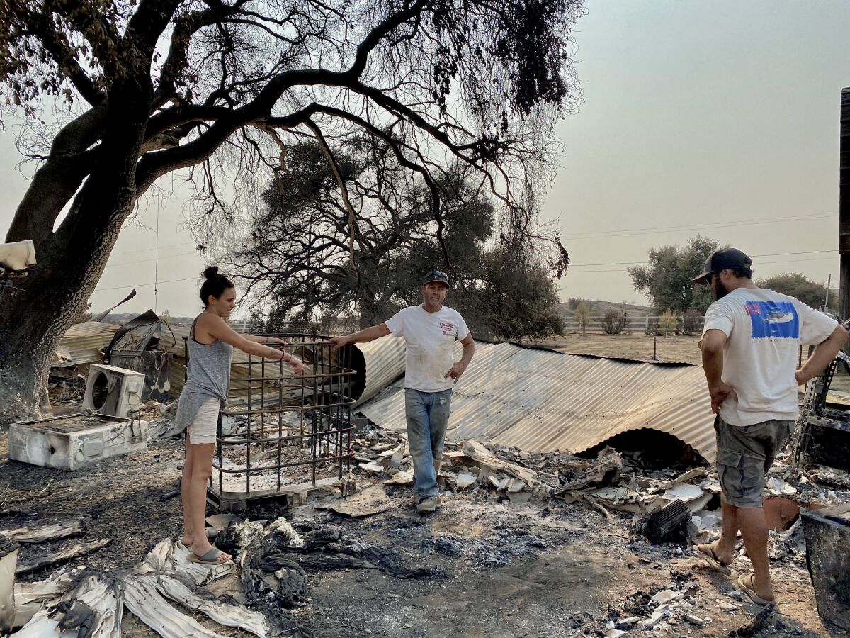 A family surveys damage to its ranch in Jamul, in San Diego County. 